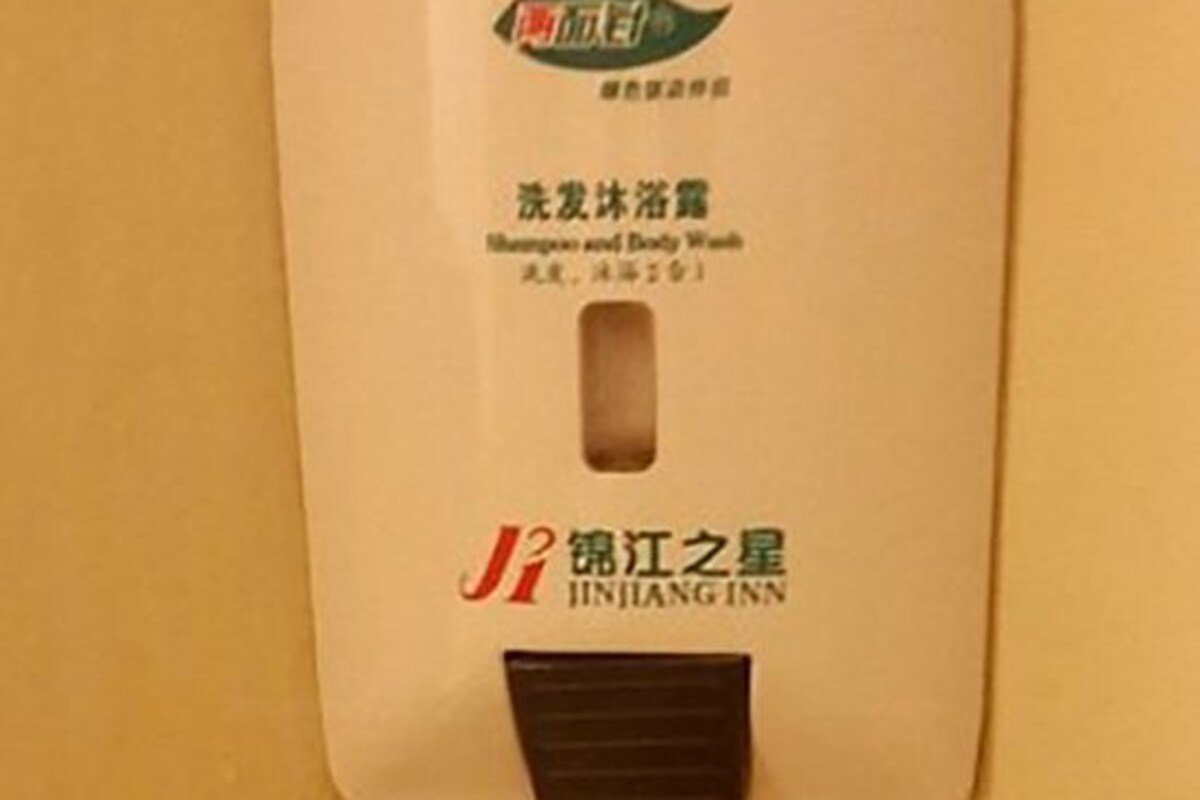 A shampoo and body wash package with a brown cap and a label that includes Chinese characters and the name 'JIJIANG INN'.