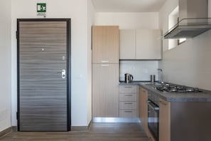 A modern kitchen with a built-in stove, a coffee maker, and a stainless steel sink.