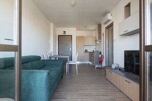 A modern apartment with a living area, kitchenette, and a dining space.