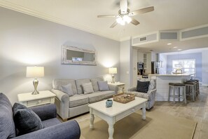 A living room with a sofa, two side tables with lamps, a coffee table, and a ceiling fan.