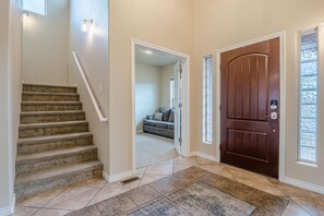 A staircase leading to a living area with a dark wooden door and a rug on the floor. - Sunshine II – Bike Path Access, Close to Town (Fruita)