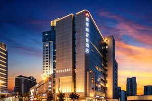 A modern hotel building with multiple floors and a prominent signage. - Sofis Pop Hotel (Fuzhou)