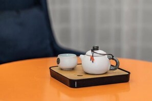 A white teapot and cup on a tray, placed on an orange table. - Sofis Pop Hotel (Fuzhou)