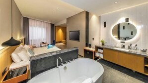 A modern hotel room with a large bathtub, a TV, a round mirror, and a seating area with a sofa and curtains. - Sofis POP Hotel (Fuzhou)