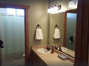 A bathroom with a double sink, a mirror, and two white towels hanging on hooks. - Raspberry Bear Lake Lodge - 6 Bed 3 Bath. Great View Of The Lake! Perfect For Big Families! (Garden City)