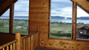 A room with large windows offering a view of a lake and distant mountains. - Raspberry Bear Lake Lodge - 6 Bed 3 Bath. Great View Of The Lake! Perfect For Big Families! (Garden City)