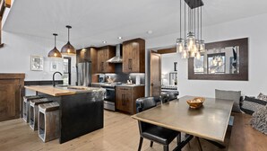A modern kitchen with wooden cabinets, stainless steel appliances, and a central island. - Beautiful Views! Jacuzzi, Indoor/ Outdoor Fireplace, Steps to Lake Estes (Estes Park)
