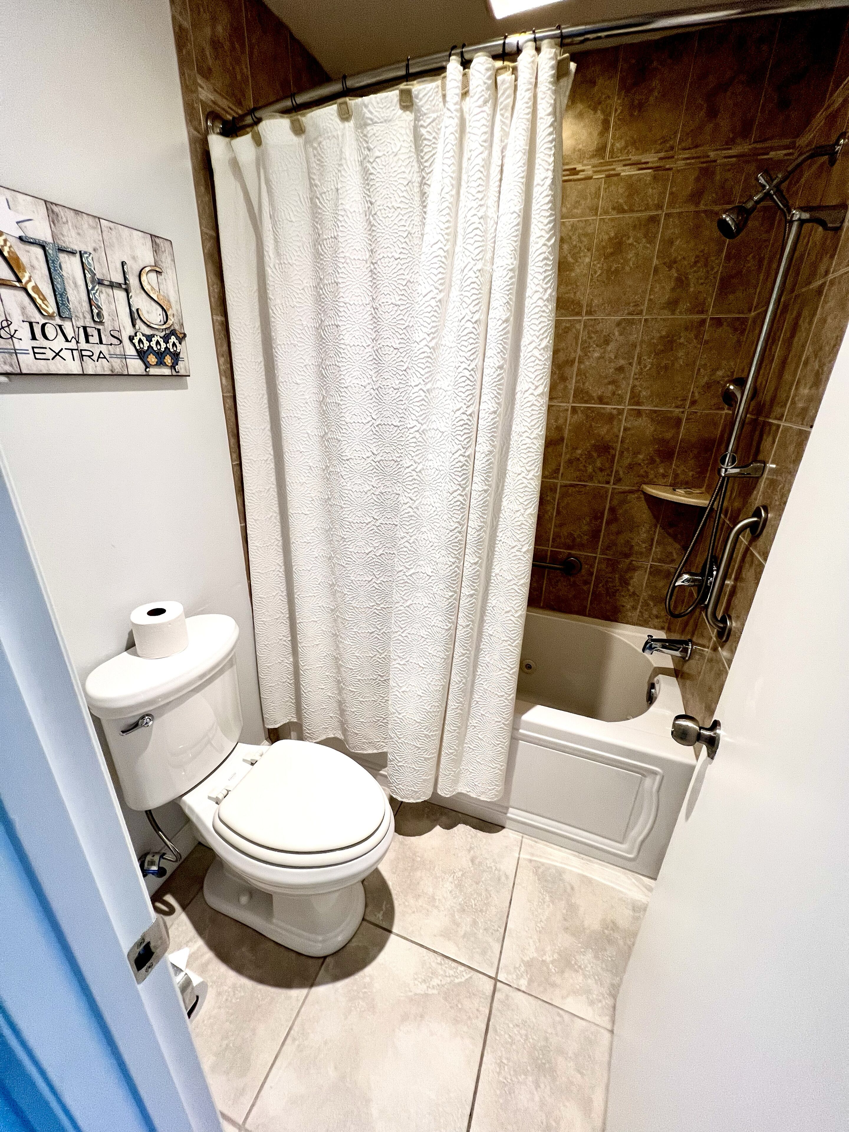 A bathroom with a toilet, shower, and bathtub.