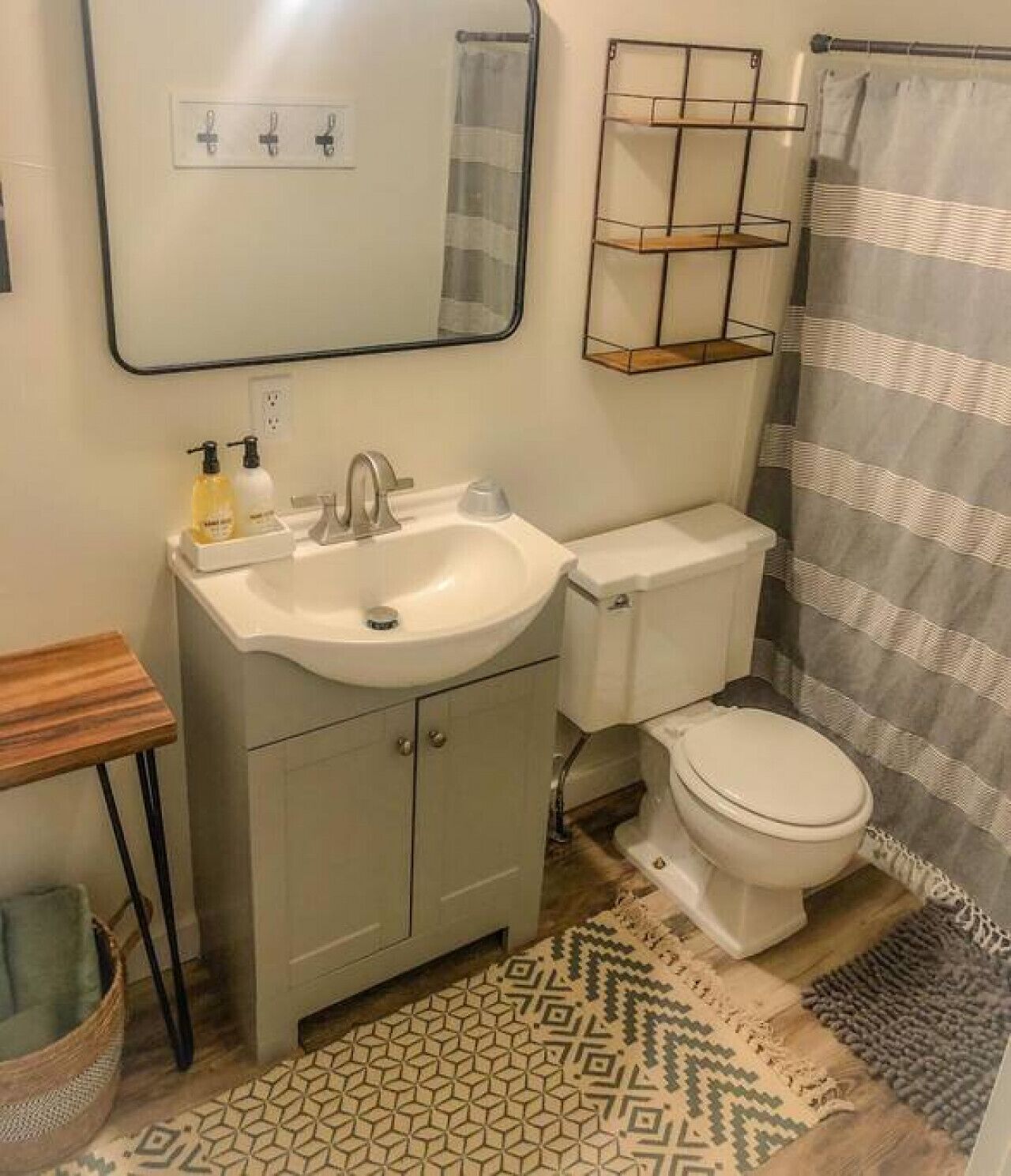 Un baño con lavamanos blanco, inodoro, espejo y cortina de ducha.