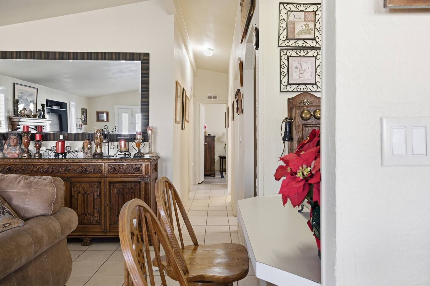 A living room with a wooden dining table, chairs, a sofa, and a kitchen area in the background.