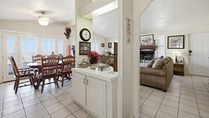 A spacious living area with a dining table, chairs, a sofa, and a fireplace.