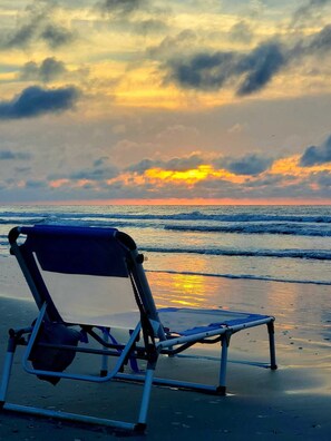 A beach chair on a sandy shore with a sunset in the background. - HS-1127 Ocean View Condo in Myrtle Beach - 1 Bedroom, Sleeps 6 (Myrtle Beach)