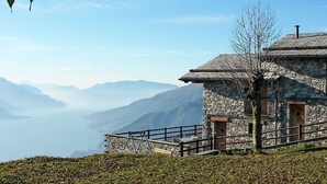 Un edificio de piedra con barandilla metálica, con vistas a un paisaje montañoso.