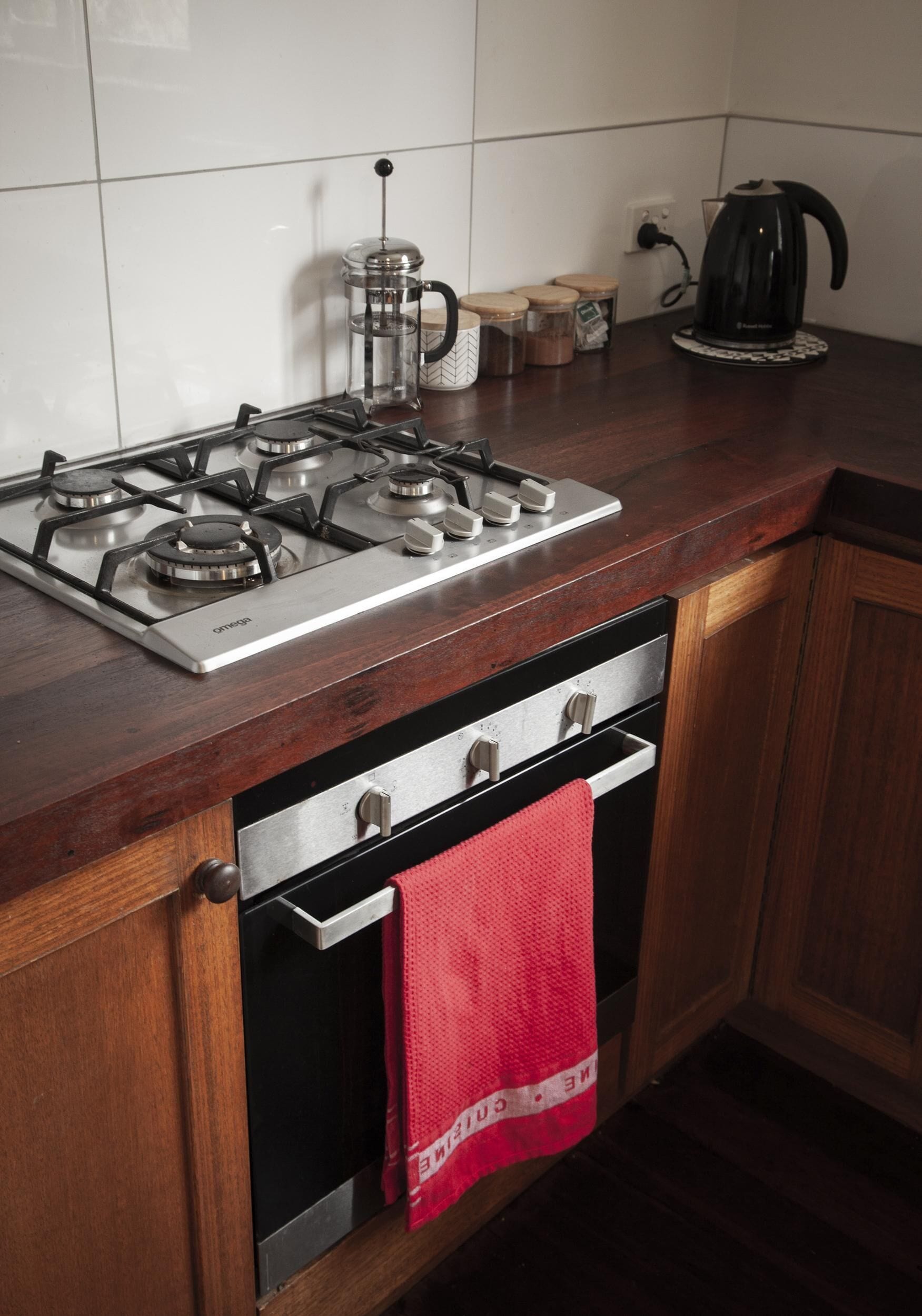 A kitchen with a gas stove, oven, and a coffee maker on the counter.