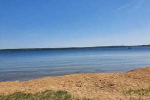 A beach with a sandy shore and calm water. - Apartment Hafenflair on Lake Plauer (Plau am See)
