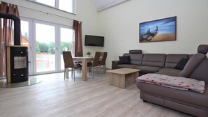 A modern living room with a sofa, a coffee table, a TV, and a fireplace.
