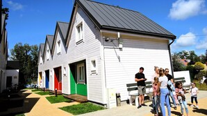 A white building with a black roof, multiple doors, and a small garden area. - Apartment in Dziwnów by Baltic Sea Beach (Dziwnow)