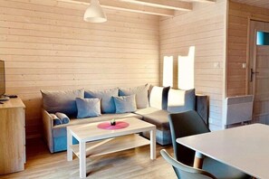 A cozy living room with a sofa, a coffee table, and a dining table. - Apartment in Dziwnów by Baltic Sea Beach (Dziwnow)