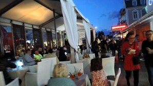 An outdoor dining area with tables and chairs, a covered section, and a crowd of people. - Apartment in Dziwnów by Baltic Sea Beach (Dziwnow)
