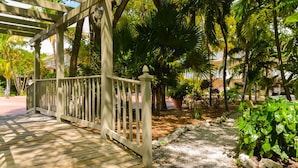 A wooden deck with a white railing leading to a covered area. - Key West Oasis! 2BR Villa with Pools and Marina at Coconut Mallory Resort (Key West)