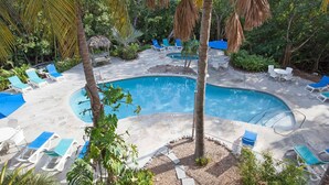 A pool area with lounge chairs and palm trees. - Key West Oasis! 2BR Villa with Pools and Marina at Coconut Mallory Resort (Key West)