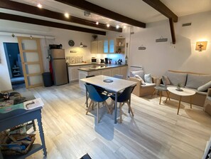 Um espaço compacto com cozinha, área de refeições e assentos.