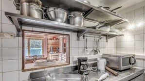 Eine moderne Küche mit Edelstahlgeräten, einem Backofen und einer Kaffeemaschine.