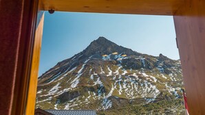 Bergblick vom Holzhaus bei blauem Himmel.