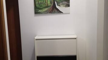 Ein Flur mit Mosaikboden, einem weißen Schrank und einem Wandbild einer Waldszene.