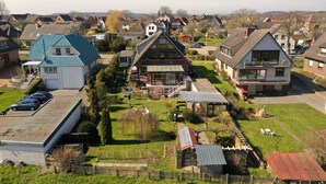 A residential area with houses, a grassy yard, and a small building with a sloped roof.