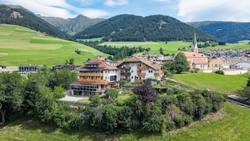 Un barrio residencial con casas, una iglesia y montañas al fondo.