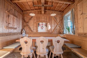 Un intérieur en bois avec un plafond haut, des bancs en bois et une table centrale.