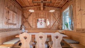 A wooden interior with a high ceiling, wooden benches, and a central table. - Comfortable Apartment “Treyer 3 Typ B” with Mountain View, Balcony & Garden (Terenten / Pustertal)