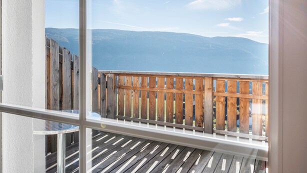 A balcony with a wooden railing, a view of distant mountains, and a clear sky. - Comfortable Apartment “Treyer 3 Typ B” with Mountain View, Balcony & Garden (Terenten / Pustertal)