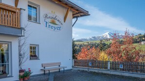 Un immeuble avec une enseigne indiquant « Résidence Treyer » et une vue sur une montagne.
