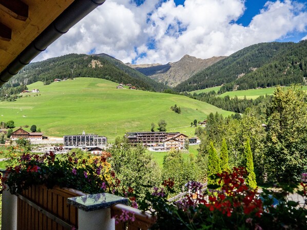 A mountain landscape with a view of a hotel and surrounding greenery.