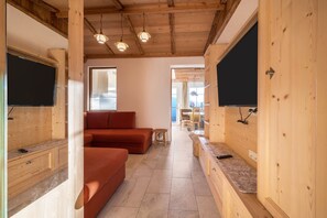A wooden interior with a sofa, a small round table, and a bench.