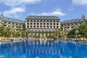A large hotel with a central swimming pool, multiple balconies, and a classic architectural style. - Wyndham Garden Haikou South (Haikou)