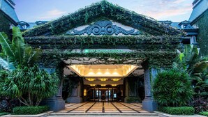 The entrance of Wyndham Garden with a covered entrance, steps leading up to it, and lush greenery surrounding the area. - Wyndham Garden Haikou South (Haikou)