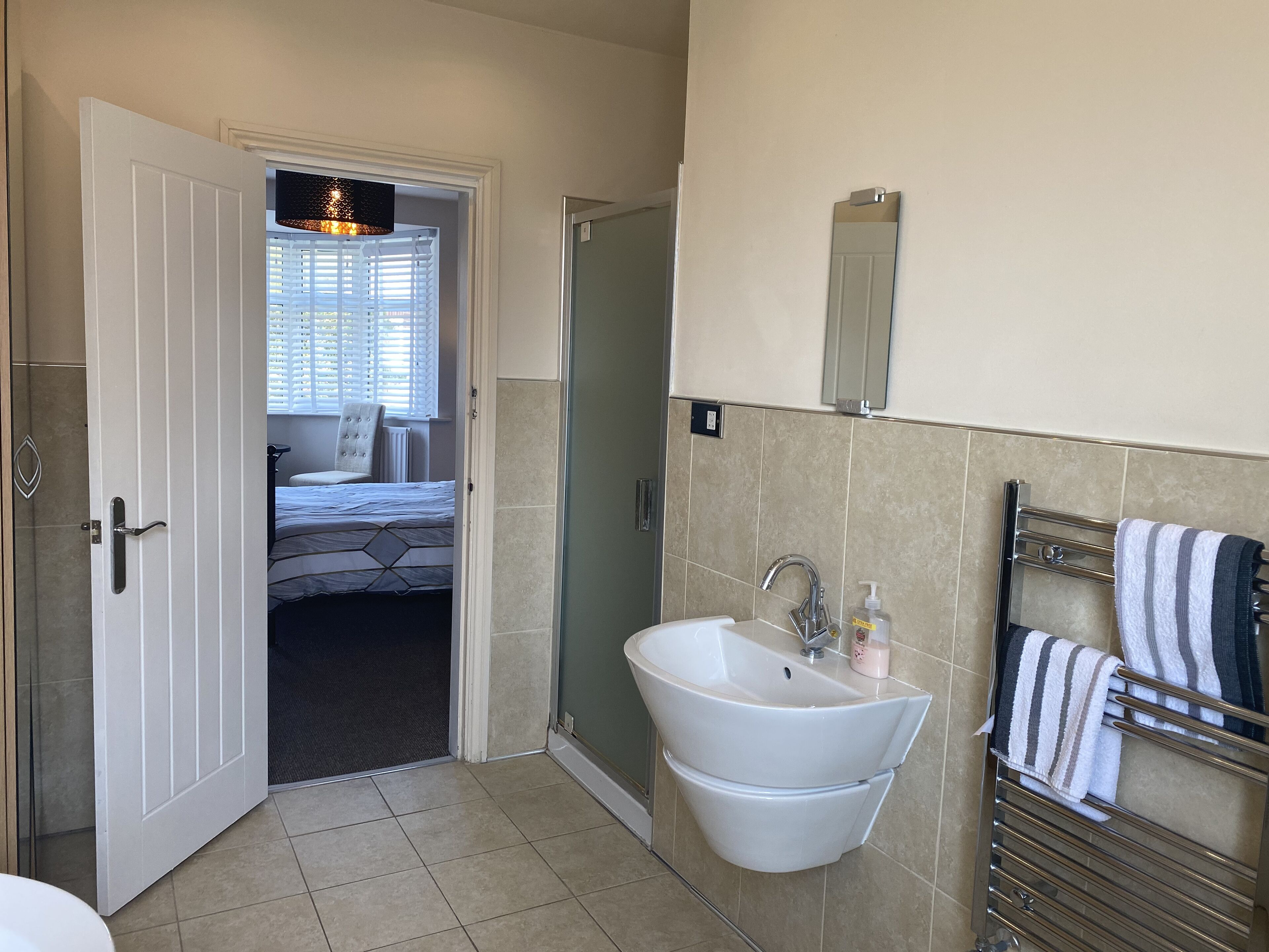 Ein Badezimmer mit Waschbecken, Spiegel und Handtuchhalter.