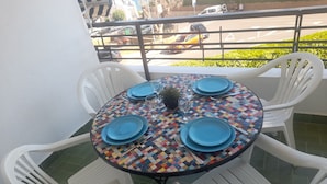 A round table with blue plates, white chairs, and a colorful tablecloth. - Beautiful apartment facing the sea (Mont-roig del Camp)