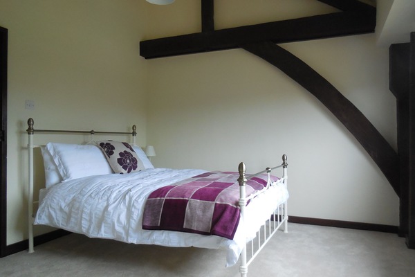 Main bedroom with kingsize bed and exposed beams