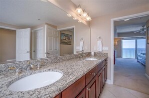 A bathroom with two sinks, a large mirror, and a ceiling fan. - 902 Sanibel - Oceanfront Panoramic Views (Daytona Beach Shores)