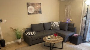 A modern living room with a grey sofa, a coffee table, and decorative pillows. - Located in # 6 golf community, close to First Health Moore Regional Hospital.  (Pinehurst)