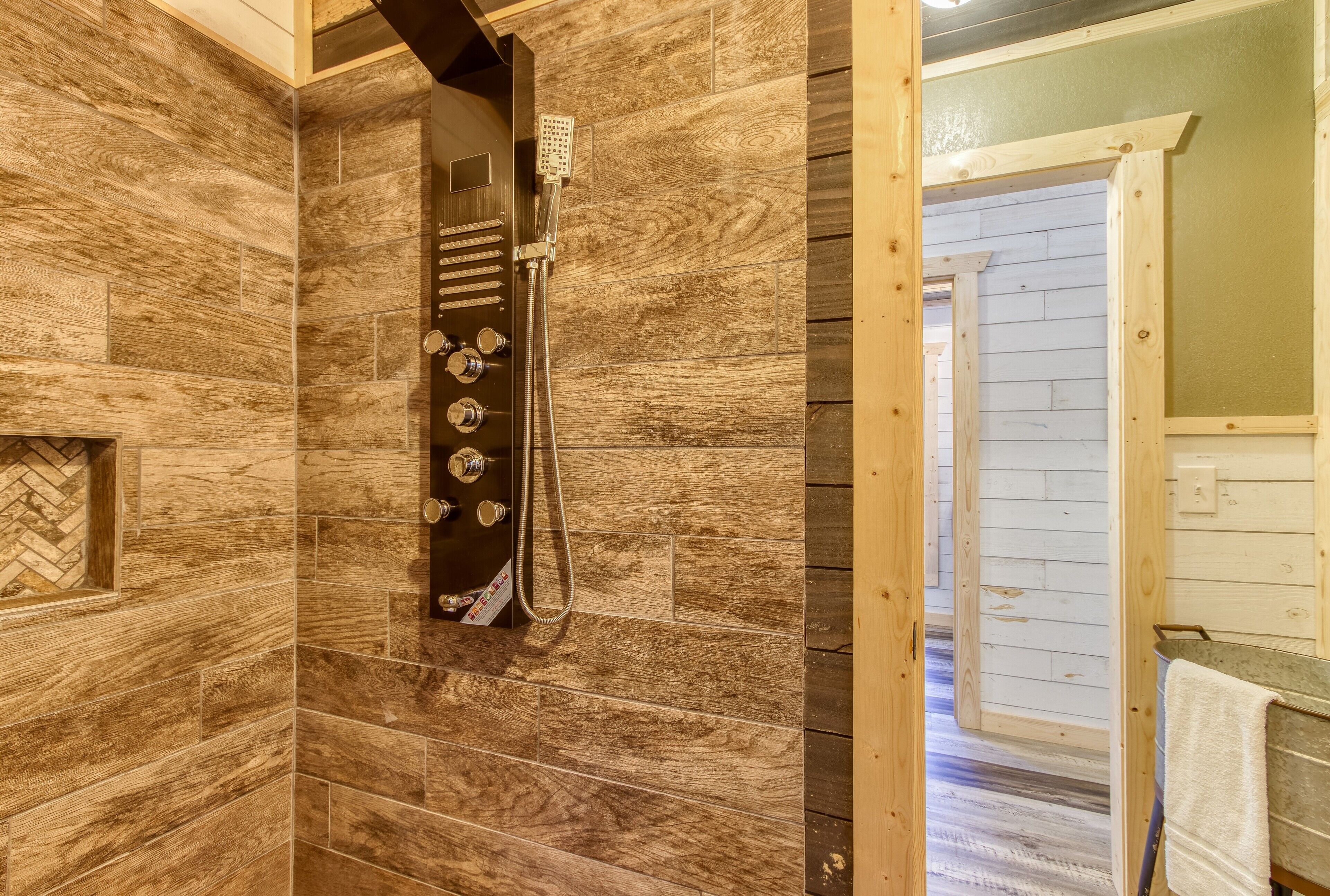 A bathroom with wooden walls and a shower area.
