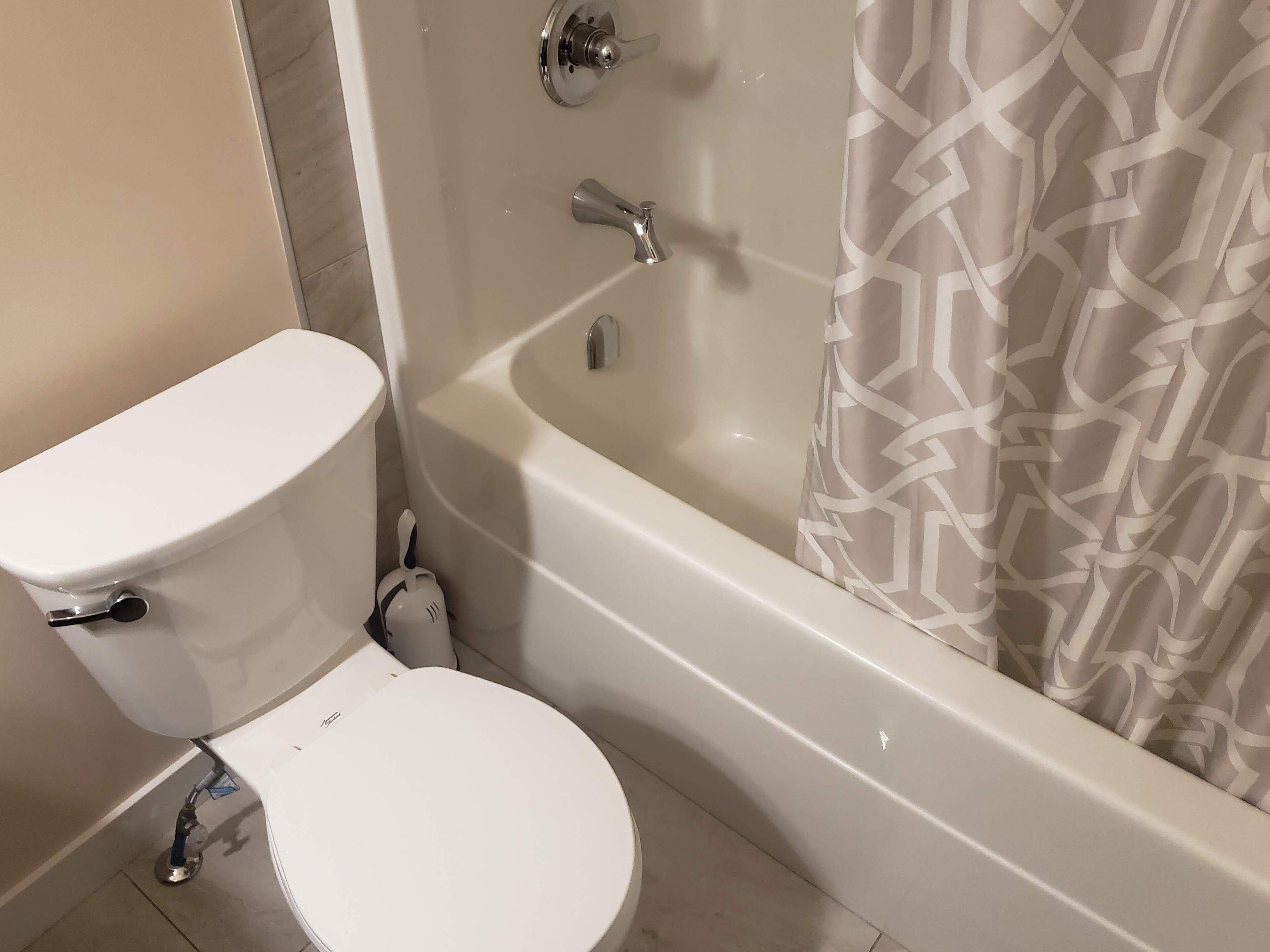 Un baño con inodoro, bañera y cortina de ducha.
