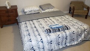 A bedroom with a bed, a nightstand, a chair, and a window. - 3 Bedroom Furnished Apartment  suitable for Company Staff with Large Yard  Space (Fort McMurray)