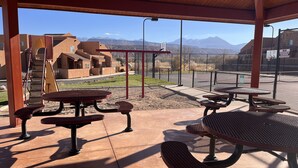 An outdoor patio area with picnic tables and a playground. - 18A4 Moab Adventure! Pool with Red Rock Views (MOAB)
