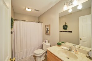 Bathtub, hair dryer, towels, toilet paper
