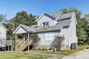 A two-story house with a front porch, a wooden staircase, and a small deck. - Ridge Retreat 42  Sleeps 8 + Crib (Taylorsville)
